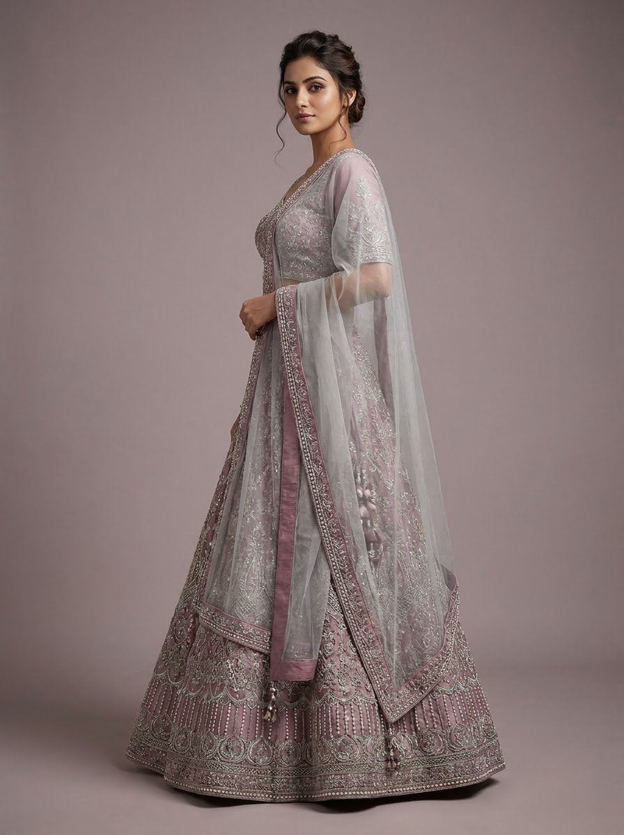 Model wearing dusty rose anarkali bridal lehenga with silver zari embroidery and sheer net jacket dupatta overlay